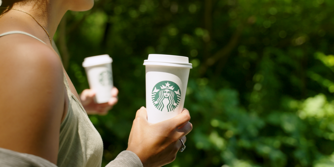 Une femme tient une boisson chaude Starbucks